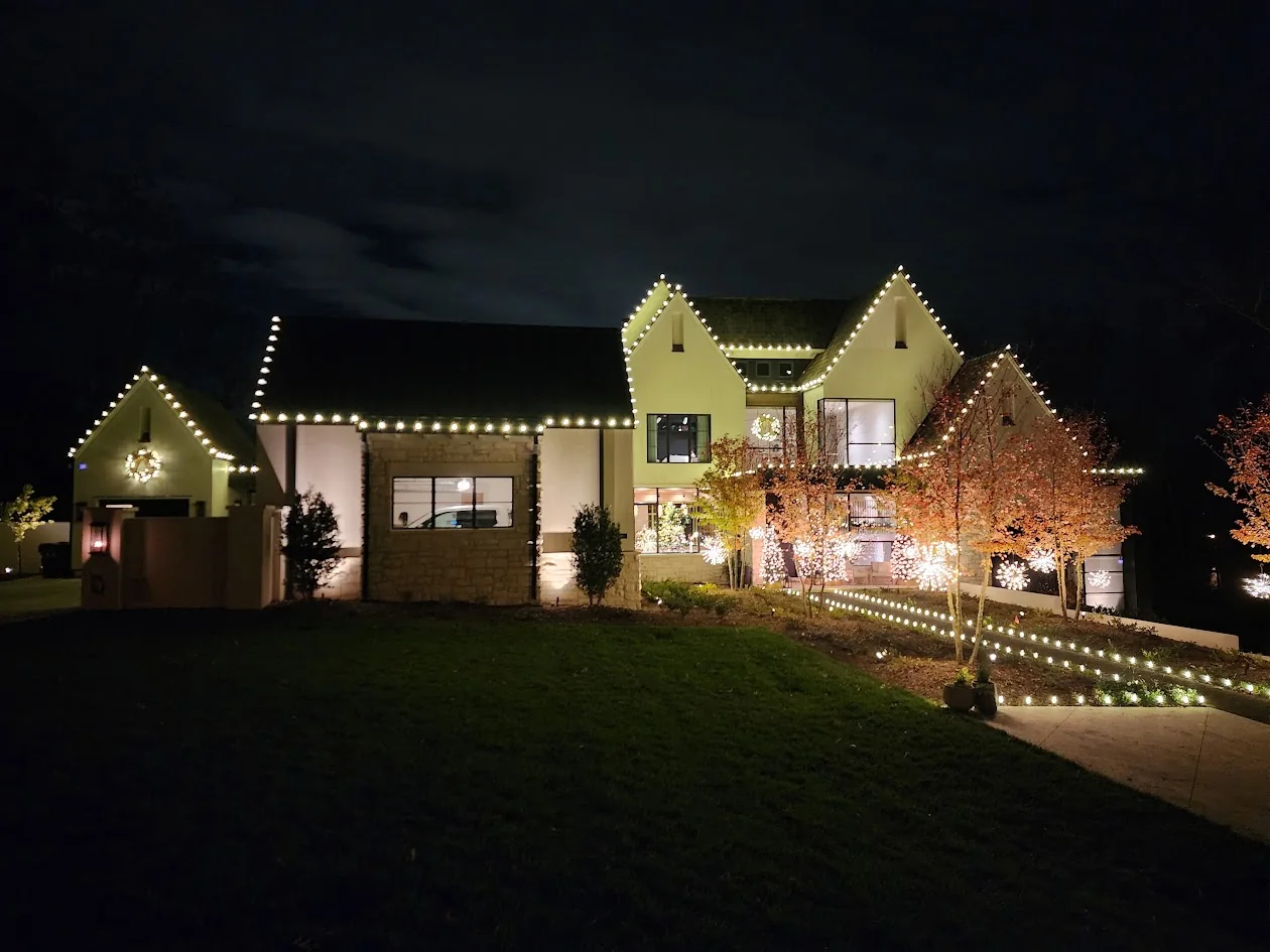 Warm white roofline and landscape Christmas lights on a Charlotte home